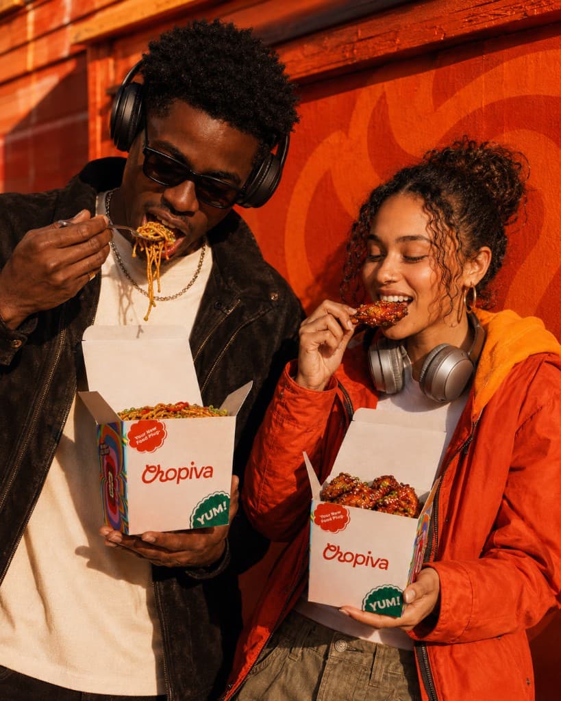 Two friends eating Chopiva wings and noodles outside